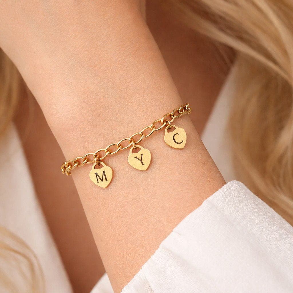 Gepersonaliseerde gouden armband met hartbedels, gegraveerd met letters